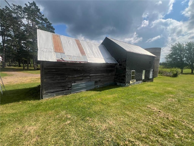 view of property exterior featuring an outbuilding and a yard