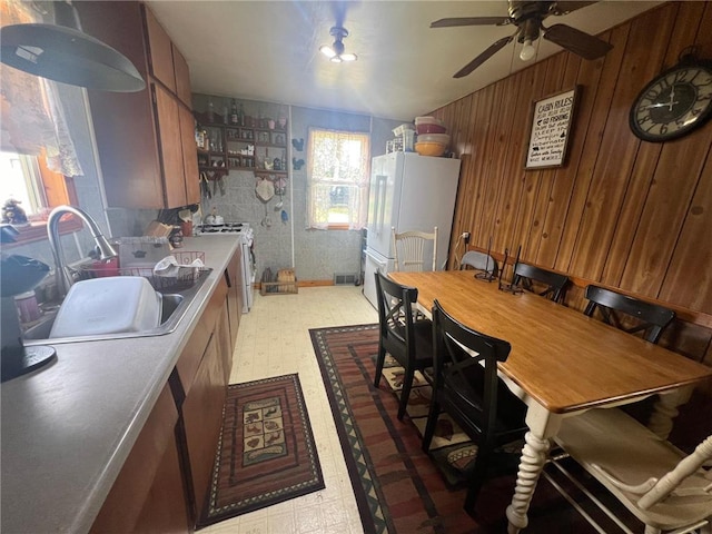 kitchen featuring white refrigerator, ceiling fan, plenty of natural light, and sink