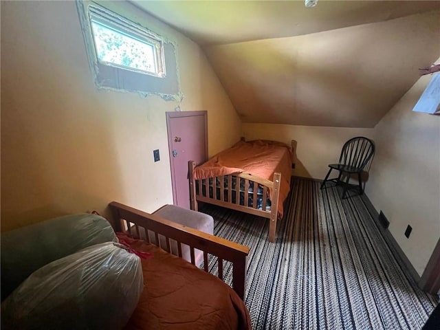 bedroom featuring vaulted ceiling and dark colored carpet