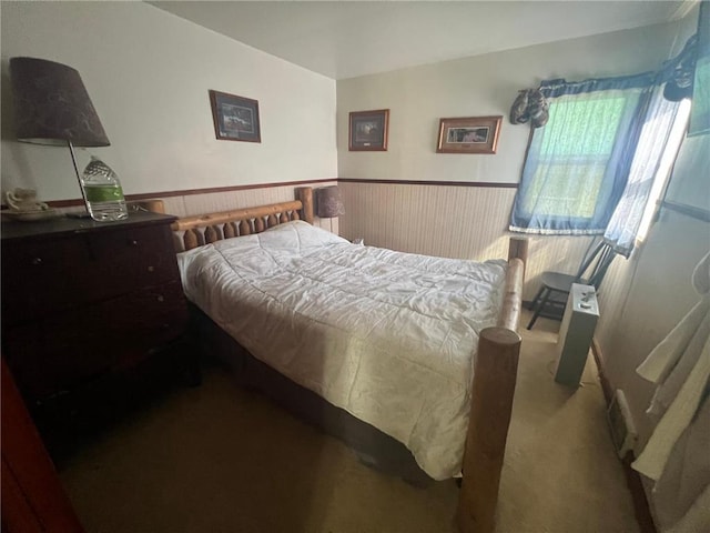 bedroom with wood walls and carpet