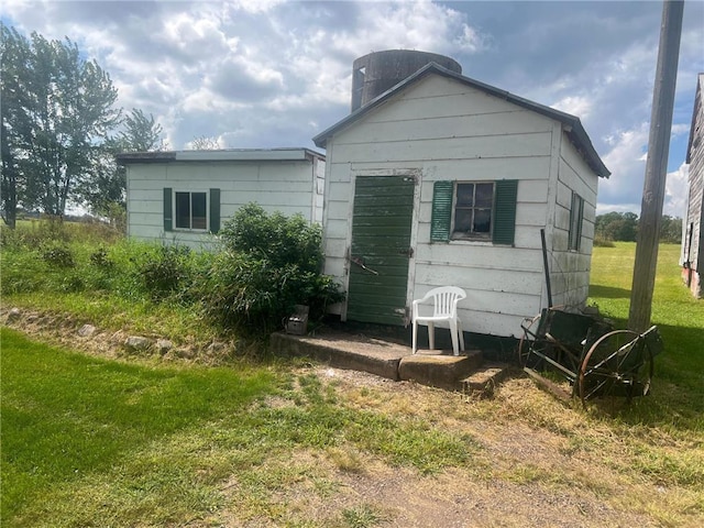 rear view of property featuring a yard