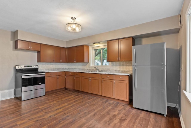 kitchen featuring backsplash, dark hardwood / wood-style floors, sink, and appliances with stainless steel finishes