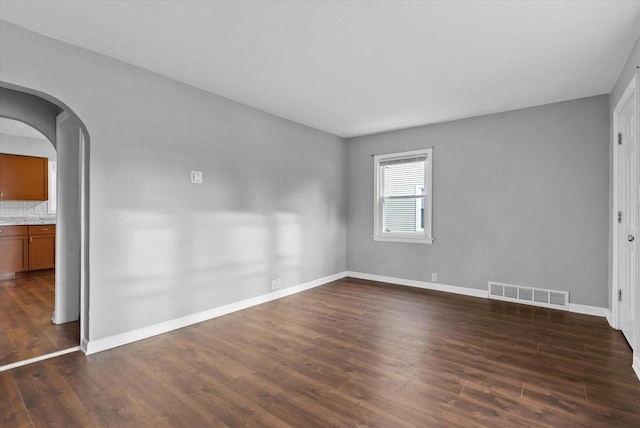 spare room featuring dark wood-type flooring