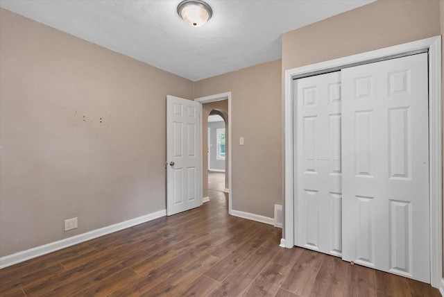 unfurnished bedroom featuring a closet and dark hardwood / wood-style floors