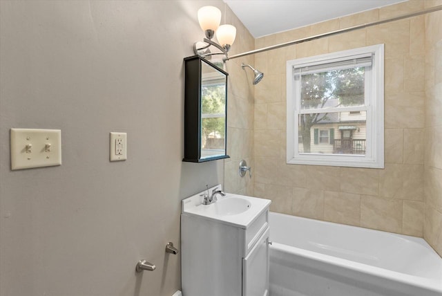 bathroom featuring tiled shower / bath and vanity