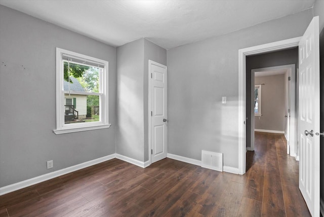 empty room with dark hardwood / wood-style flooring