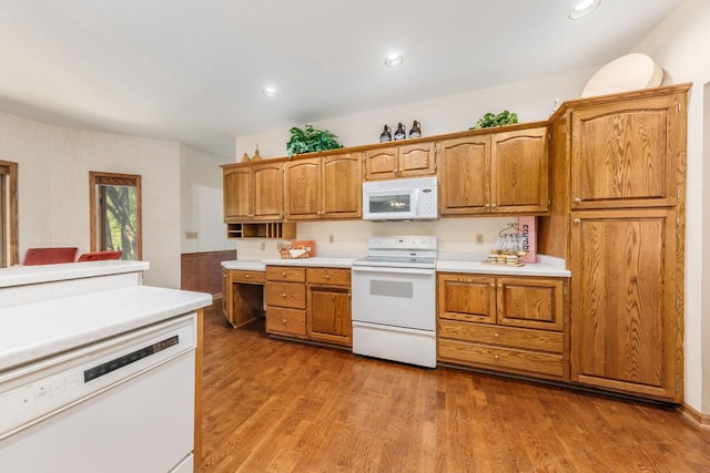 kitchen featuring white appliances, wood finished floors, and light countertops