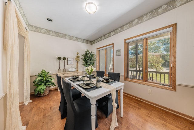 dining space featuring light wood-style floors and baseboards