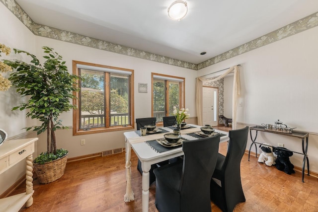 dining room featuring baseboards, visible vents, and light wood finished floors