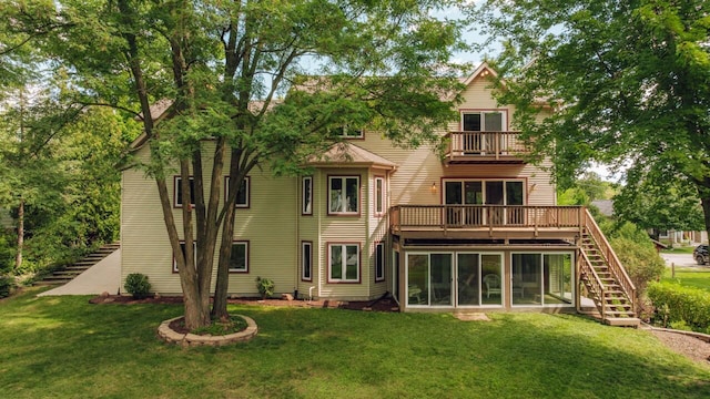 rear view of house with stairway, a balcony, a yard, and a sunroom