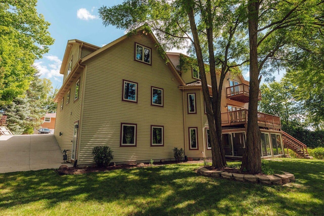 back of property featuring a lawn and stairs