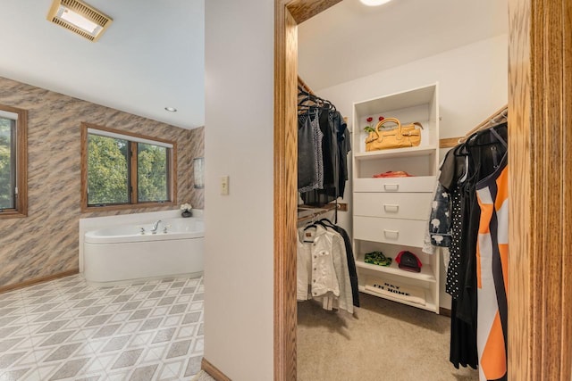 full bath featuring baseboards, visible vents, wallpapered walls, a spacious closet, and a bath