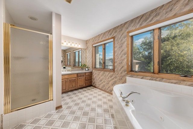 bathroom with vanity, a tub with jets, baseboards, wallpapered walls, and a stall shower