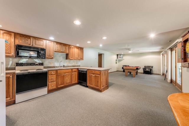 kitchen featuring black appliances, a sink, recessed lighting, a peninsula, and light colored carpet