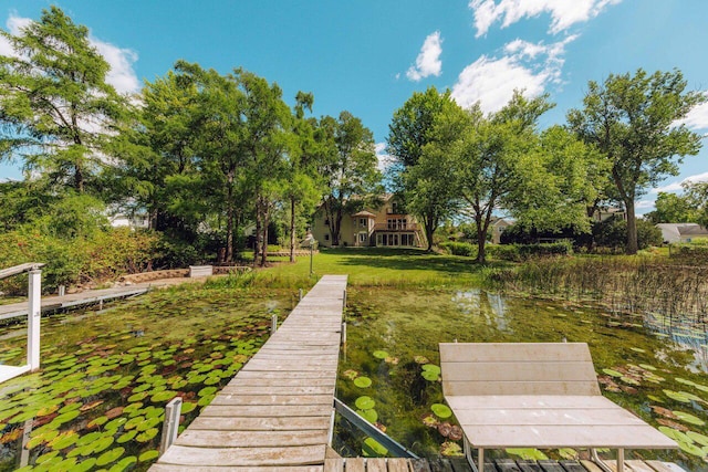 view of dock with a lawn