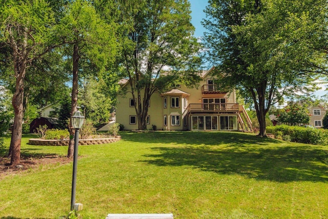 rear view of house featuring a yard, a wooden deck, and stairs