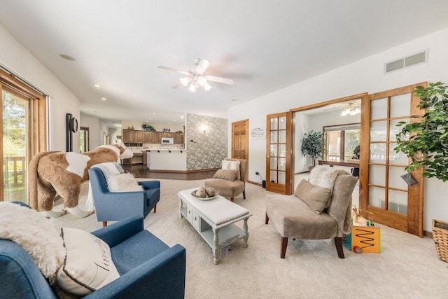 living room featuring visible vents, french doors, a ceiling fan, and carpet floors