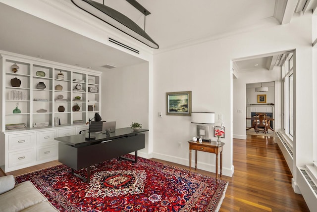 office area featuring visible vents, dark wood-type flooring, baseboards, and ornamental molding