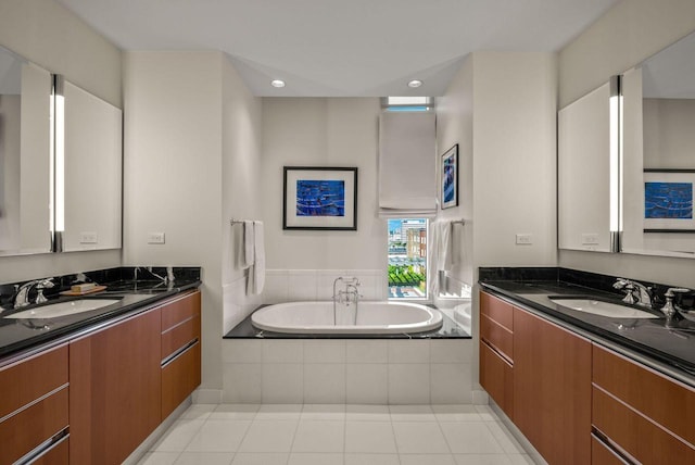 full bathroom featuring tile patterned flooring, a bath, two vanities, and a sink