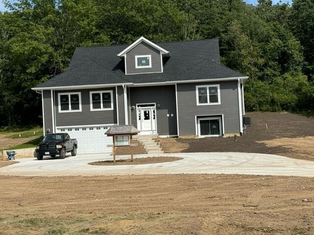 view of front of house featuring central air condition unit and a garage