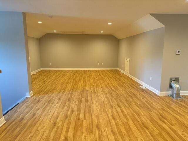 interior space featuring lofted ceiling and light hardwood / wood-style floors