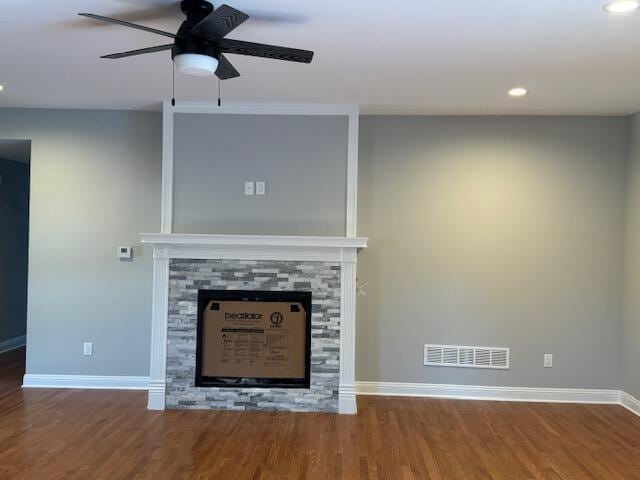 unfurnished living room with a stone fireplace, ceiling fan, and hardwood / wood-style flooring