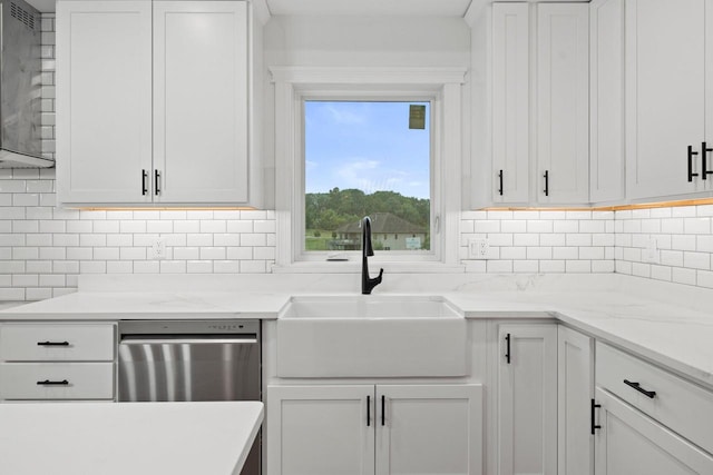 kitchen with light stone counters, white cabinets, backsplash, and sink