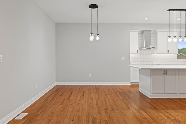 unfurnished dining area featuring light wood-type flooring