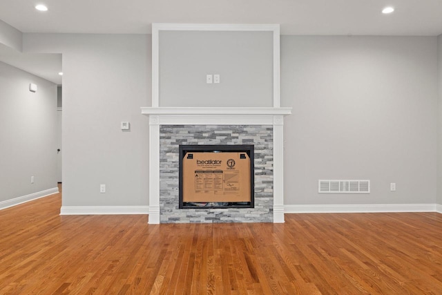 room details featuring hardwood / wood-style flooring and a stone fireplace