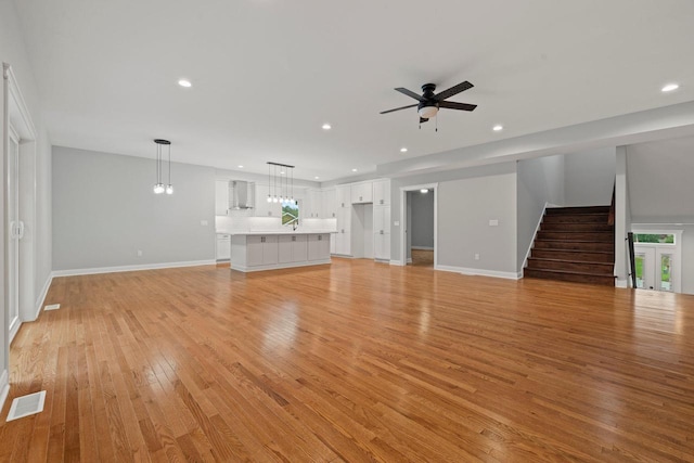 unfurnished living room with ceiling fan and light wood-type flooring