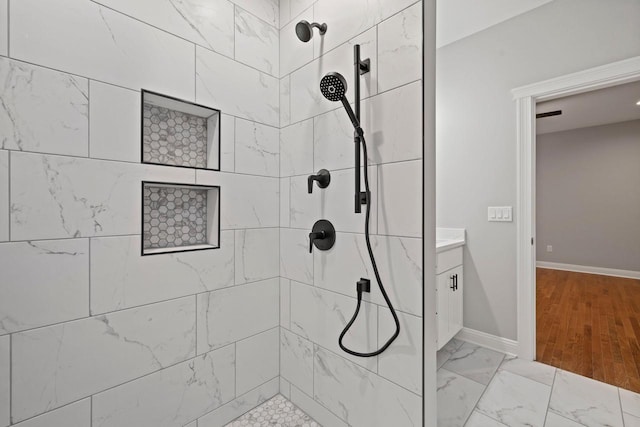 bathroom featuring vanity, hardwood / wood-style floors, and tiled shower