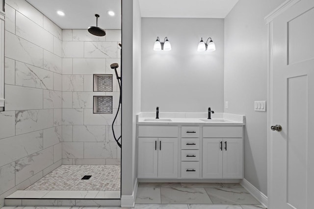 bathroom featuring tiled shower and vanity