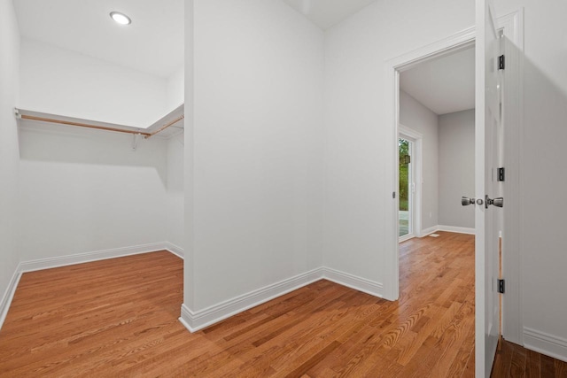 walk in closet with light hardwood / wood-style flooring