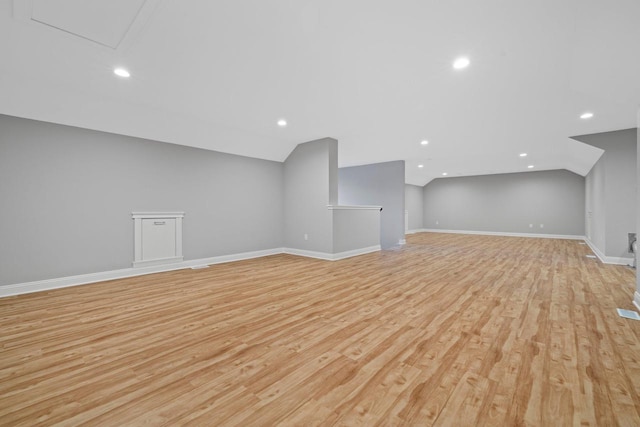 bonus room with vaulted ceiling and light hardwood / wood-style flooring