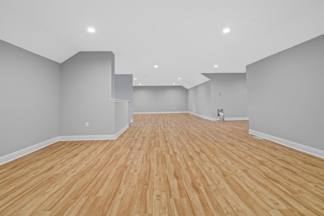 additional living space with light hardwood / wood-style floors and lofted ceiling