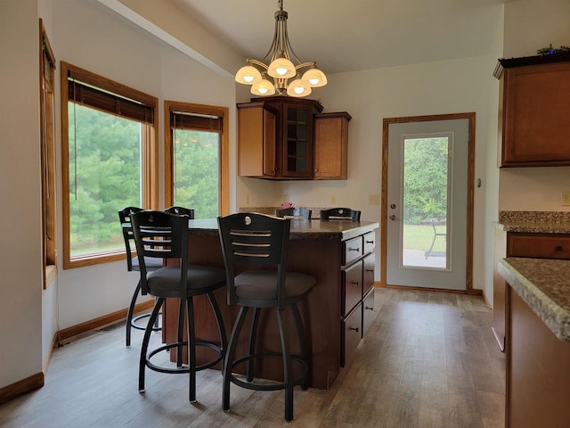 kitchen with decorative light fixtures, a chandelier, a wealth of natural light, and light hardwood / wood-style floors