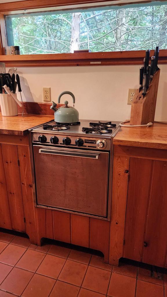 N697 County Rd N, Neshkoro, WI 54960 - kitchen with gas range, butcher block countertops, light tile patterned floors, and brown cabinets