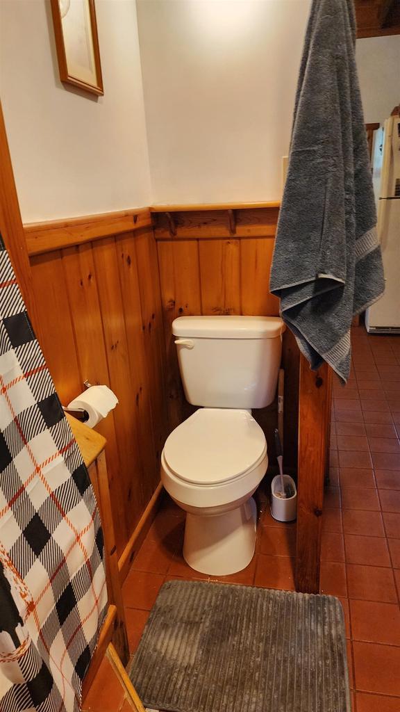 N697 County Rd N, Neshkoro, WI 54960 - bathroom featuring tile patterned floors, toilet, and a wainscoted wall