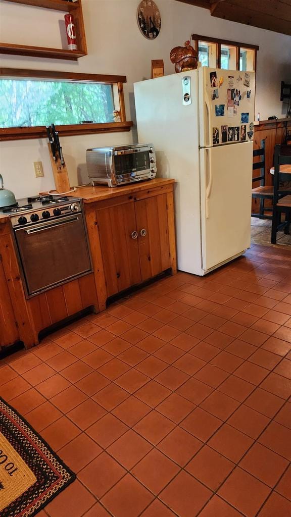 N697 County Rd N, Neshkoro, WI 54960 - kitchen featuring range with gas stovetop, freestanding refrigerator, and light tile patterned floors
