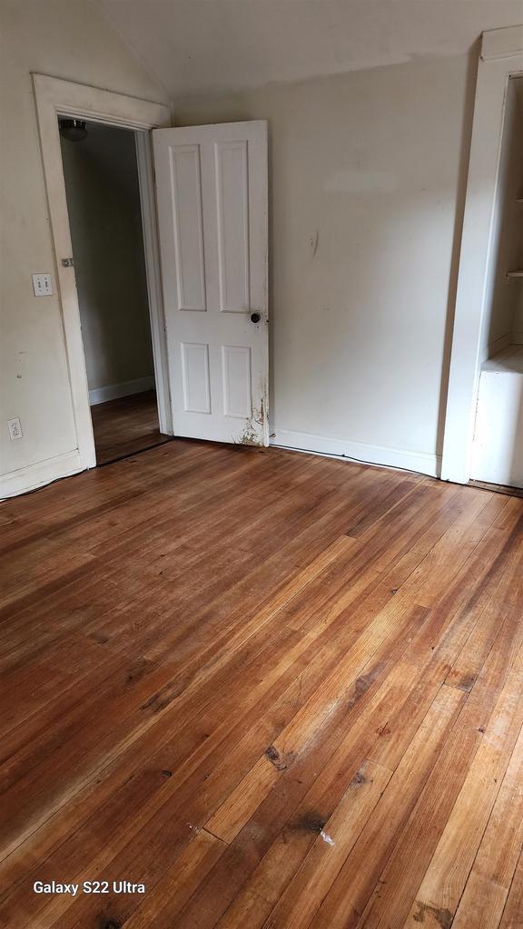 N697 County Rd N, Neshkoro, WI 54960 - unfurnished bedroom featuring hardwood / wood-style flooring and baseboards