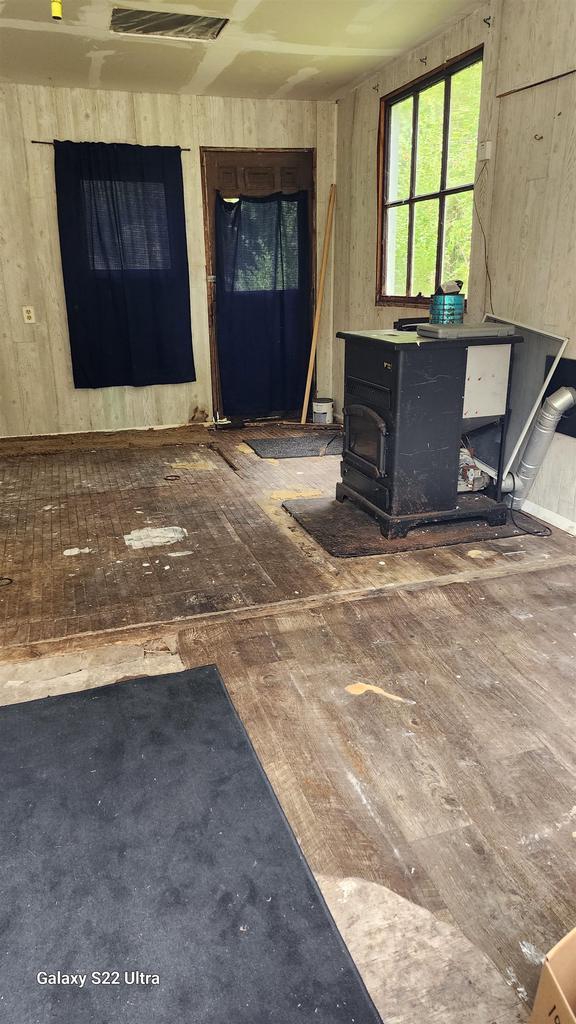 N697 County Rd N, Neshkoro, WI 54960 - unfurnished living room with a wood stove and wood walls