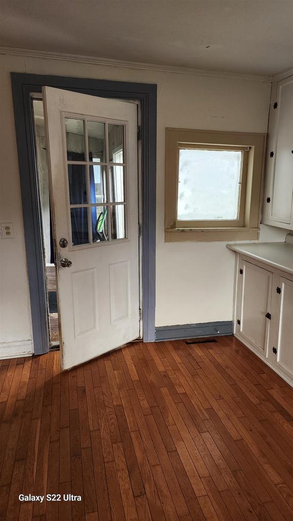 N697 County Rd N, Neshkoro, WI 54960 - unfurnished dining area with dark wood-style flooring and ornamental molding
