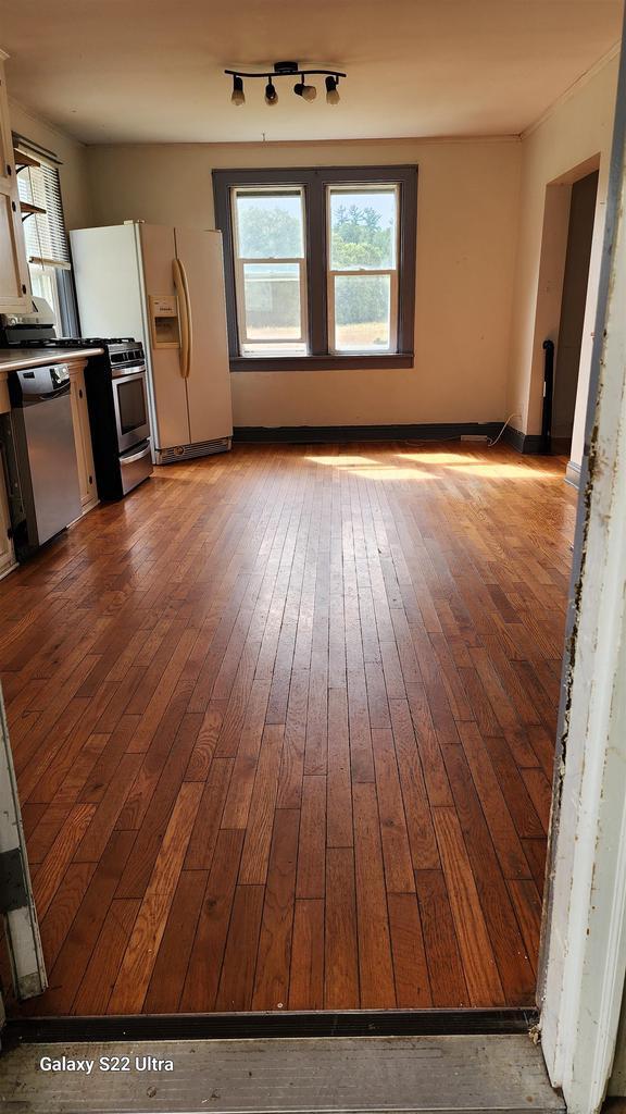 N697 County Rd N, Neshkoro, WI 54960 - unfurnished living room with hardwood / wood-style flooring and rail lighting