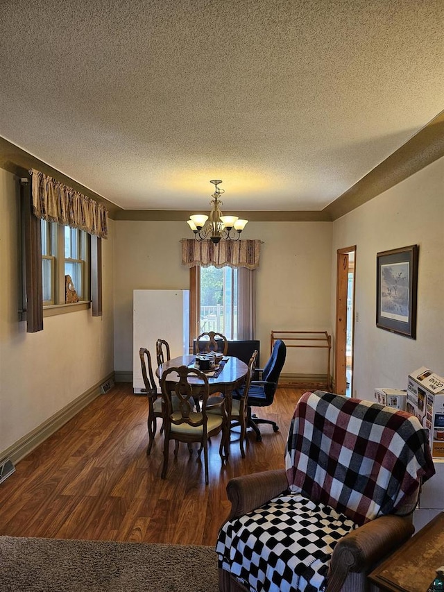 dining area featuring a textured ceiling, a chandelier, and dark hardwood / wood-style floors