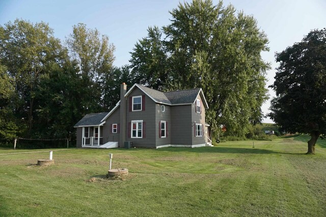 back of house with central AC and a lawn