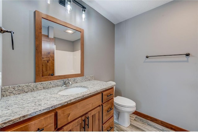 bathroom featuring vanity, toilet, and hardwood / wood-style flooring