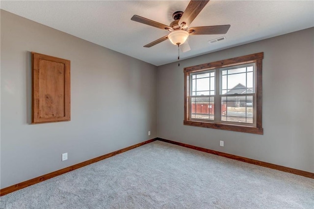 spare room featuring a textured ceiling, light colored carpet, and ceiling fan