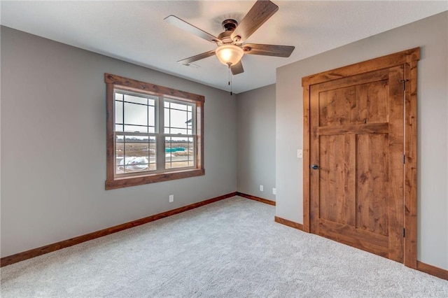 spare room featuring light colored carpet and ceiling fan