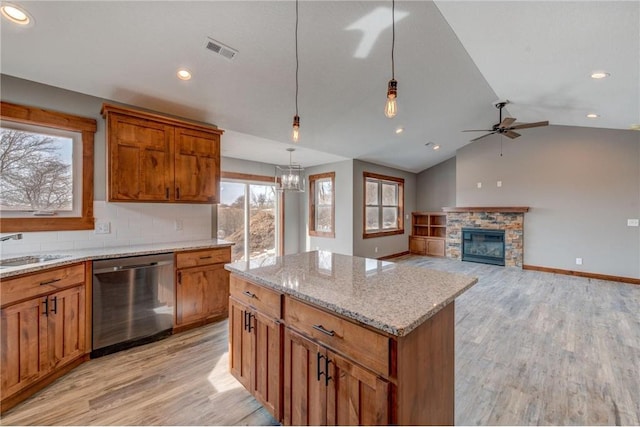 1915 Otter Way, New Richmond, WI 54017 - kitchen featuring stainless steel dishwasher, light wood-style floors, a ceiling fan, a center island, and vaulted ceiling