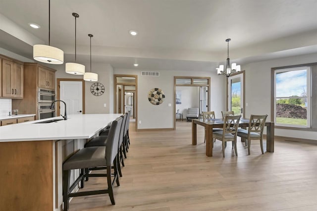 1629 N Honeysuckle Cir, De Pere, WI 54115 - dining area featuring light wood finished floors, baseboards, visible vents, recessed lighting, and an inviting chandelier